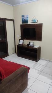 1 dormitorio con 1 cama y TV en una habitación en Paraíso tropical en Balneário Gaivotas