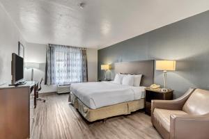 um quarto de hotel com uma cama e um sofá em Suburban Studios Salt Lake City Airport em Salt Lake City