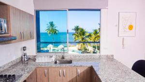 een keuken met uitzicht op de oceaan vanuit een raam bij Magico Apartamento Frente al Mar 4 Habitaciones PAZ335 in Coveñas