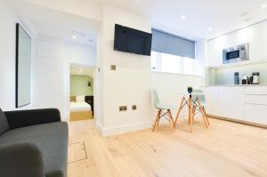 a living room with a couch and a table and a kitchen at Star Street Serviced Apartments by Concept Apartments in London