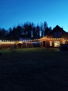 una casa iluminada por la noche con un parque infantil en Poilsis netoli Druskininkų, en Druskininkai