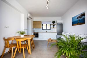 uma cozinha e sala de jantar com uma mesa de madeira e cadeiras em "Thea" Luxury Apartments with great View em Plakiás