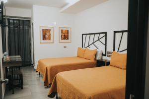 Cette chambre comprend 2 lits et une fenêtre. dans l'établissement MCI HOTEL, à San Juan de los Lagos