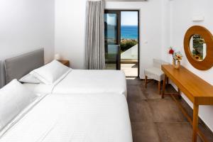 a bedroom with two beds and a desk and a mirror at "Thea" Luxury Apartments with great View in Plakias