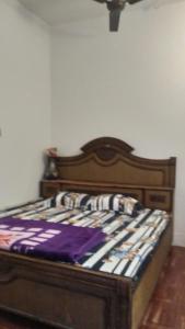 uma cama num quarto com uma moldura de madeira em Sunshine Guest House & Restaurant em Jodhpur