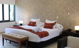 a bedroom with a large white bed with red pillows at Hotel Boutique Duranta in Villavicencio