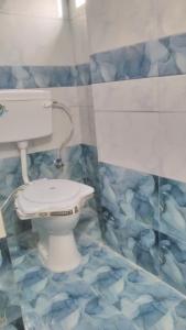 uma casa de banho com WC e piso em azulejo azul em Sunshine Guest House & Restaurant em Jodhpur