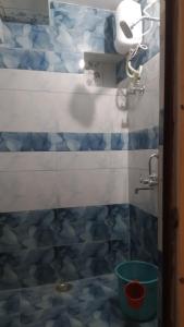 baño con una pared de azulejos azules y blancos en Sunshine Guest House & Restaurant, en Jodhpur