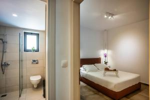 a bedroom with a bed and a shower and a toilet at "Thea" Luxury Apartments with great View in Plakias