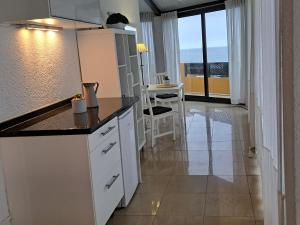 eine Küche mit weißen Schränken und Meerblick in der Unterkunft Heaven In Canary Islands 88 in Puerto de la Cruz