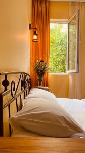 una camera con un letto con una finestra e un cuscino di GUEST HOUSE RIMAS HOME a Khulo
