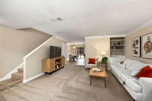 a living room with a white couch and a tv at Montrose Walk To 50 Restaurants 1 Mile 2 DT in Houston