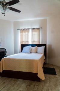 1 dormitorio con 1 cama con sábanas blancas y ventana en SKYLINE SUITES: 3 BED/3 BATH VACATION RENTAL, en Grand Anse