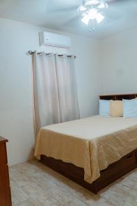 1 dormitorio con 1 cama, ventana y techo en SKYLINE SUITES: 3 BED/3 BATH VACATION RENTAL en Grand Anse