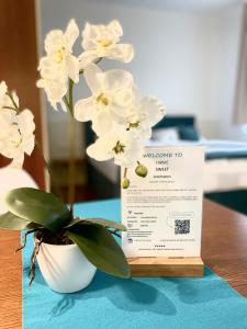 una planta blanca en un jarrón blanco sobre una mesa en Home Sweet Apartments | contactless check-in, en Viena