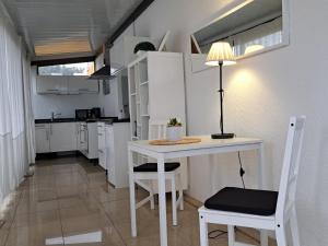 eine kleine weiße Küche mit einem Tisch und Stühlen in der Unterkunft Heaven In Canary Islands 88 in Puerto de la Cruz