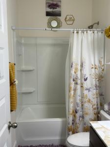 een badkamer met een douchegordijn en een toilet bij Exotic Room in Hampton