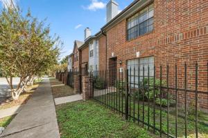 a black fence in front of a brick building at Montrose 2BR Sleeps 10 Walkable Gated Parking in Houston