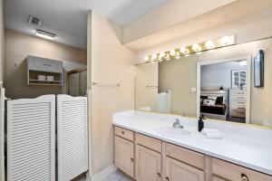 a bathroom with a sink and a mirror and a refrigerator at Montrose 2BR Sleeps 10 Walkable Gated Parking in Houston +23 photos