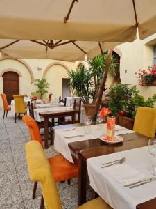 un restaurante con mesas, sillas amarillas, mesas y mesa en Unique suite at Tenuta Granducale Dolciano, en Chiusi