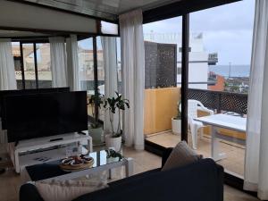 ein Wohnzimmer mit einem Flachbild-TV und einem Balkon in der Unterkunft Heaven In Canary Islands 88 in Puerto de la Cruz