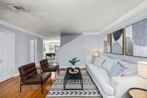 a living room with a white couch and chairs at Montrose 2-Unit Retreat 4BR Sleeps 20 Near DT in Houston
