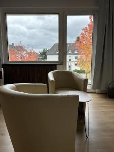 two chairs and a table in front of a window at Central Service Apartment in Recklinghausen