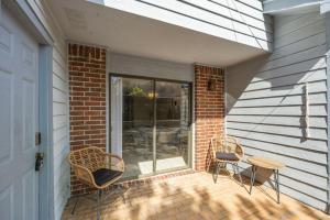 a patio with two chairs and a table next to a building at Montrose 2-Unit Retreat 4BR Sleeps 20 Near DT in Houston