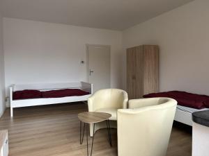 a room with two beds and a table and chairs at Central Service Apartment in Recklinghausen
