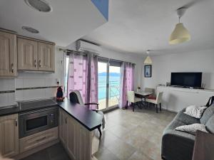 eine Küche und ein Wohnzimmer mit einem Sofa und einem Tisch in der Unterkunft Faro de Cullera I in Faro de Cullera