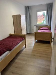 a bedroom with two beds and a window at Central Service Apartment in Recklinghausen