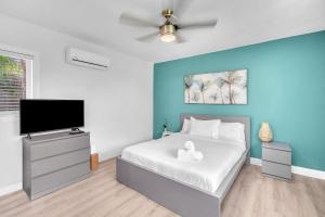 a bedroom with a bed and a flat screen tv at Blue Wave Bungalow - 1 1 - Stylish in Dania Beach