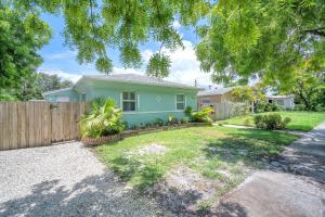 a green house with a fence in a yard at Blue Wave Bungalow - 1 1 - Stylish in Dania Beach