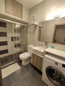 a bathroom with a toilet sink and a washing machine at Sea View Apartments Nikos in Nea Peramos