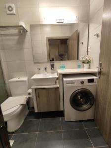 a bathroom with a toilet a sink and a washing machine at Sea View Apartments Nikos in Nea Peramos
