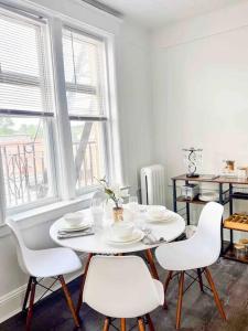 a white table and chairs in a room with windows at Bright, Stunning Downtown Apt, Close to Proctors in Schenectady