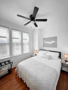 a white bedroom with a bed and a ceiling fan at Bright, Stunning Downtown Apt, Close to Proctors in Schenectady