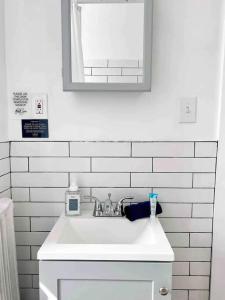 a white sink in a bathroom with a mirror at Bright, Stunning Downtown Apt, Close to Proctors in Schenectady