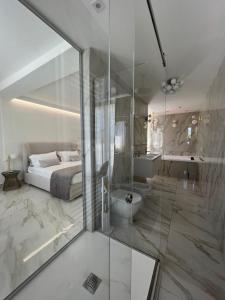 a bedroom with a bed and a bathroom with a shower at ANAMA camere & suite in Lucera