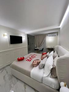 a bedroom with a large bed with red pillows at ANAMA camere & suite in Lucera
