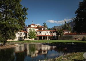 una casa grande con un estanque frente a ella en Gran Hotel Potrerillos en Potrerillos