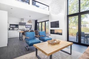 ein Wohnzimmer mit einem Tisch und blauen Stühlen in der Unterkunft Holiday Home Maridu Forest Cube in Arnhem