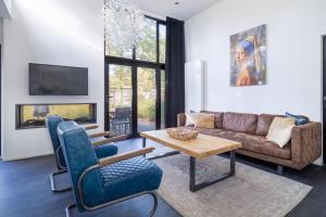 ein Wohnzimmer mit Sofa und Tisch in der Unterkunft Holiday Home Maridu Forest Cube in Arnhem