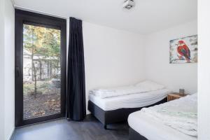 2 aparte bedden in een kamer met een raam bij Holiday Home Maridu Forest Cube in Arnhem