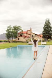 kobieta stojąca przed basenem w obiekcie Gran Hotel Potrerillos w mieście Potrerillos