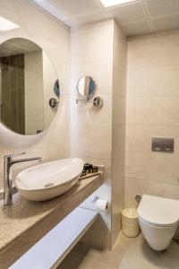 a bathroom with a sink and a toilet and a mirror at FAME HOTEL in Kemer