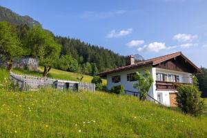 una casa en una colina con un campo de hierba en Ferienhaus Lehen, en Berchtesgaden