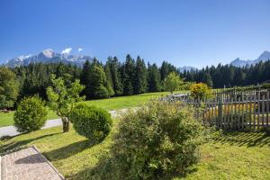 um jardim com cerca, árvores e montanhas em Ferienhaus Lehen em Berchtesgaden