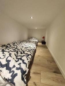 a bedroom with a black and white comforter on a bed at Grand volume calme centre-ville Tan1 in Cambrai