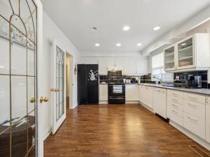 uma cozinha com armários brancos e piso de madeira em Harmony Room Creative Living in Toronto em Toronto